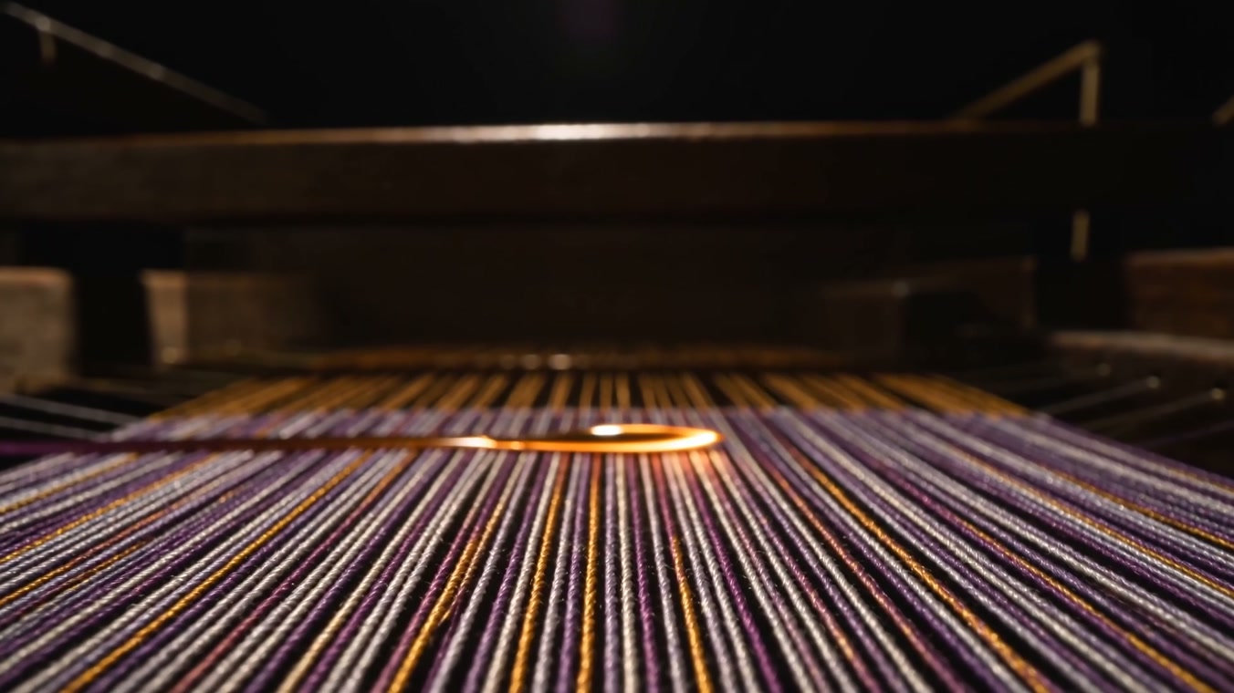 Warp threads on the loom, a shuttle of light crossing